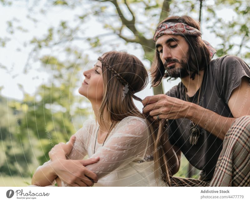 Hippie couple sitting while he combs her hair relax hippie free happy love braid relationship emotion freedom hipster liberty lifestyles party peace relaxing