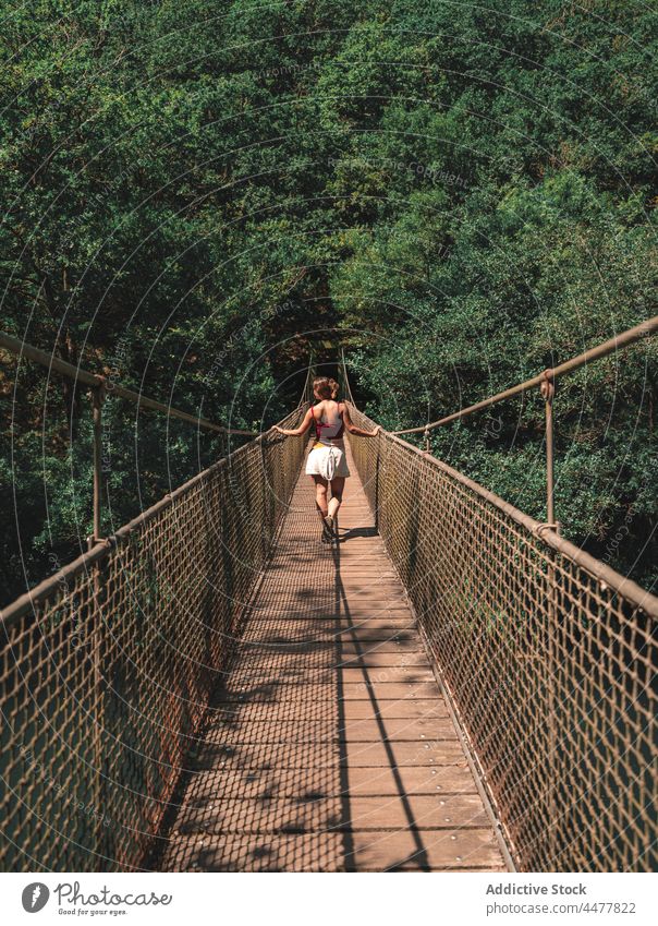 Traveling woman on bridge in forest traveler suspension park footbridge explore adventure female fragas do eume spain nature destination explorer woodland woods