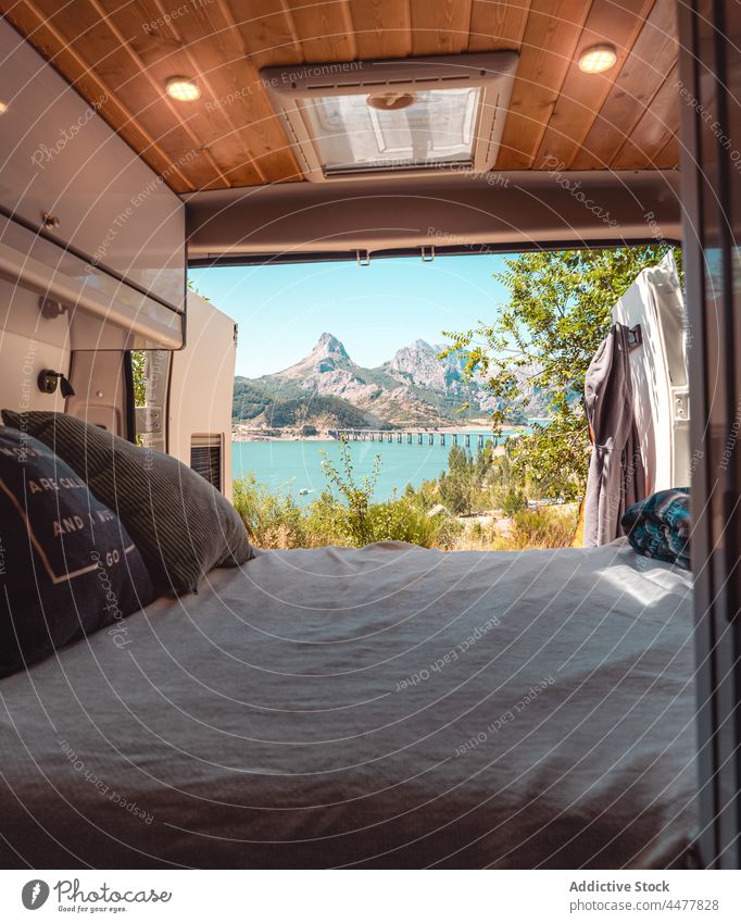 Bed in traveling van parked in highlands camper bed caravan lake mountain cozy blanket riano leon italy cushion nature pillow comfort vehicle soft design summer