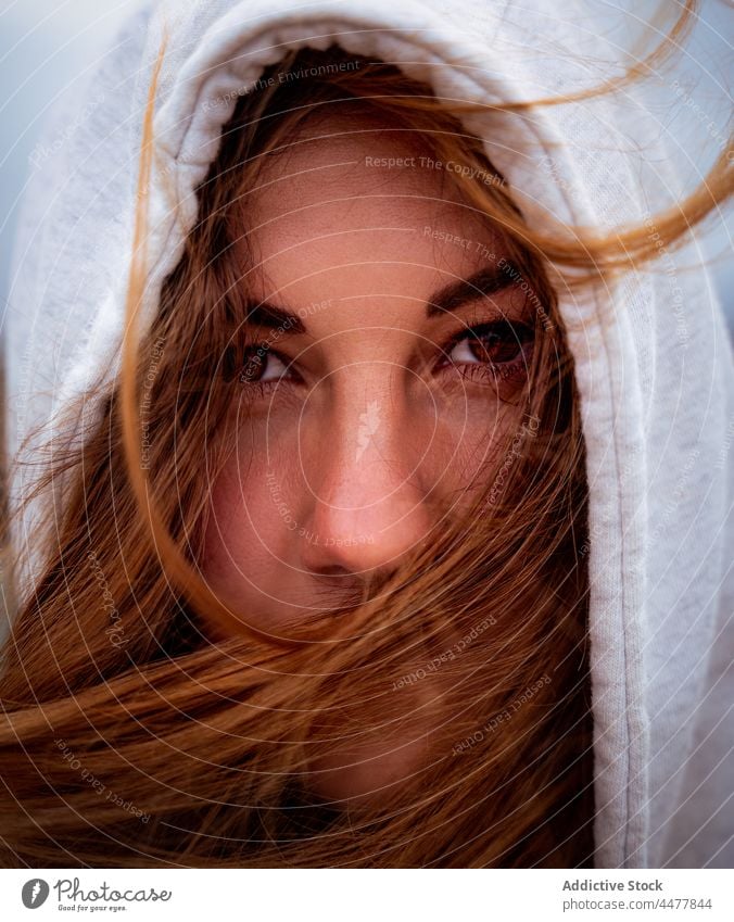 Redhead woman in hood looking at camera ginger hair enigma charming appearance portrait flying hair wind redhead female galicia spain lady individuality natural