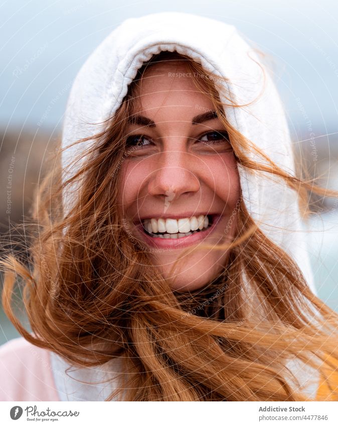 Redhead woman in hood looking at camera ginger hair cheerful enigma charming appearance delight portrait flying hair wind redhead female galicia spain lady