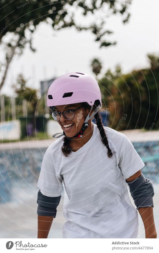 Cheerful African American woman in pink helmet and elbow pads skate skate park generation smile freedom protect fun inspiration toothy smile happy cheerful