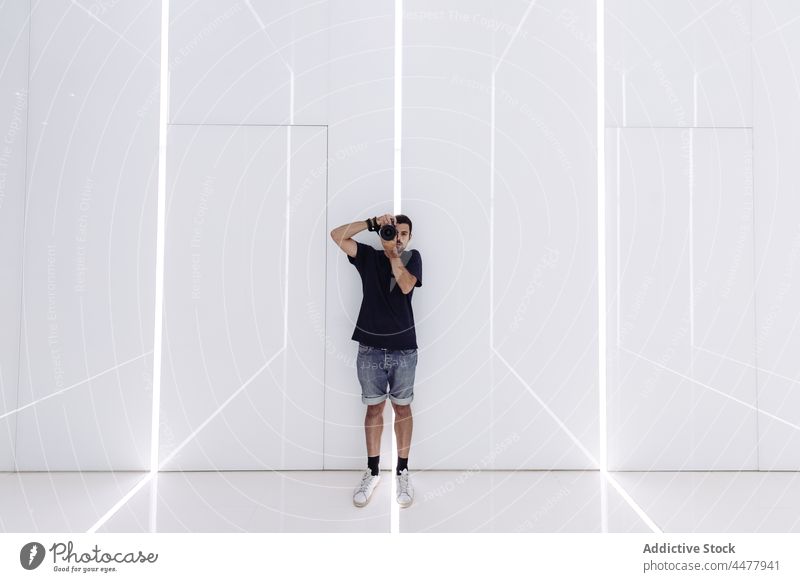 Young man photographing light corridor in modern building take photo photo camera lobby minimal architecture photography tourist photographer style design male