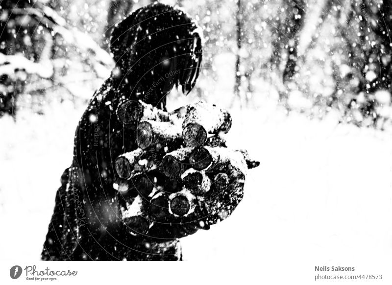 human silhouette, snowstorm, carrying firewood, working and hoping to get warm. Not for Christmas cards. black and white Snow Exterior shot White Cold Deserted