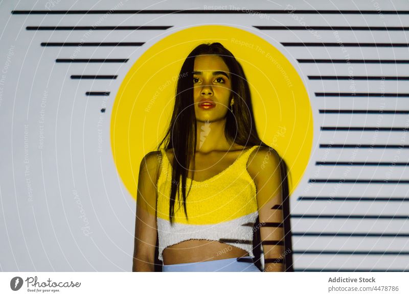 Tender ethnic model in crop top in projector light style contemplate pleasant appearance stripe woman millennial makeup hispanic cool parallel circle form