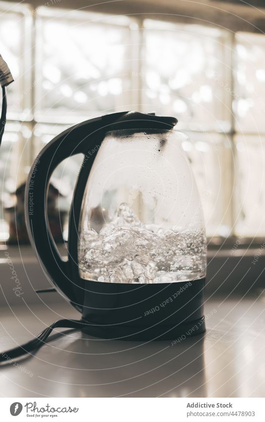 Transparent kettle with boiling water in kitchen transparent handle table utensil hot electric prepare kitchenware modern black breakfast aqua domestic liquid