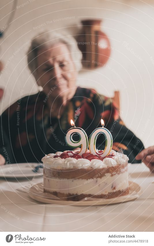 Senior female celebrating birthday with family woman celebrate cake blow candle at home clap hands 90 relative meeting event festive food party senior together