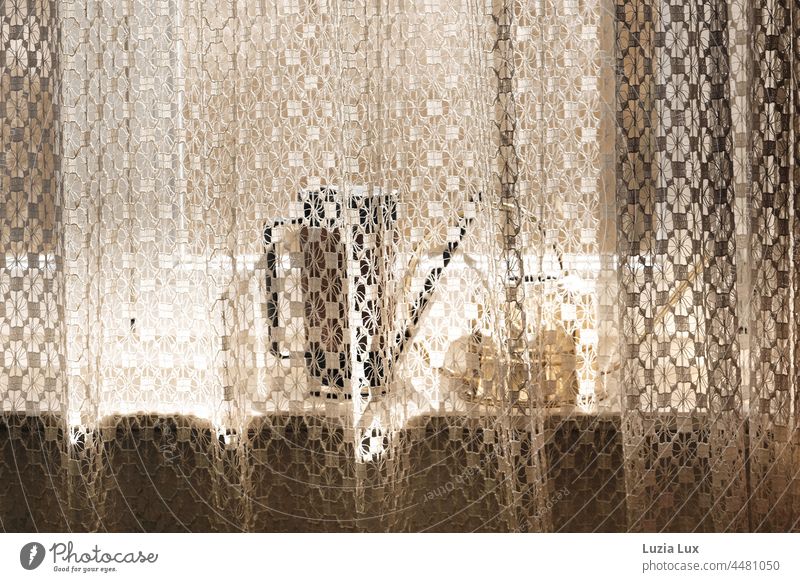 Golden light behind the curtain, between the window pane and the lace two old-fashioned watering cans Light golden light Bright kind pretty Airy sunshine