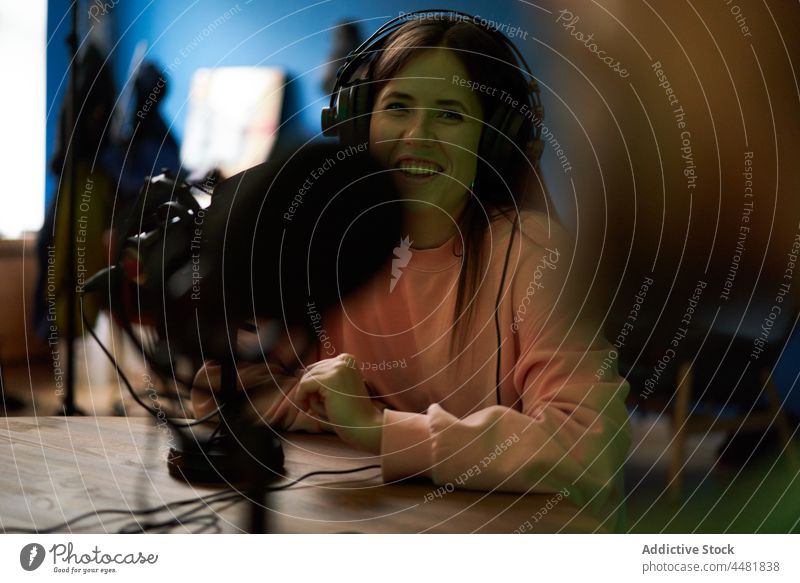 Young woman talking in mic while recording podcast with crop coworker radio communicate smile microphone host speak together colleague chat young studio audio