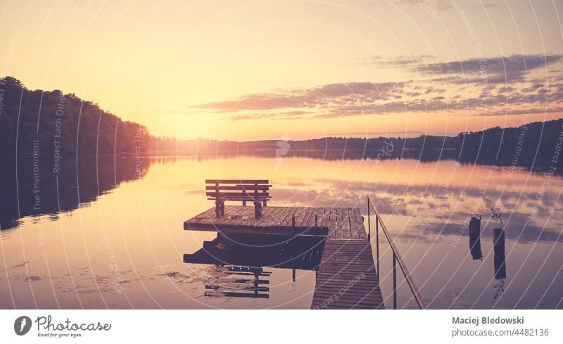 Scenic sunset over lake with wooden bench on pier. sky water landscape summer outdoor nobody travel relax sunrise calm rest horizon vacation tranquil nature