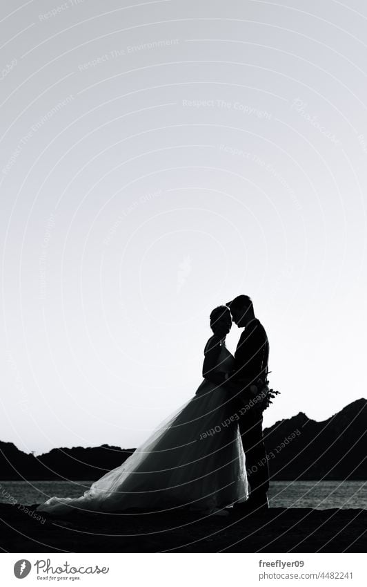 Silhouette of a just married couple against the sky wedding husband wife love copy space silhouette sea backlight heterosexual bride groom sunset portrait