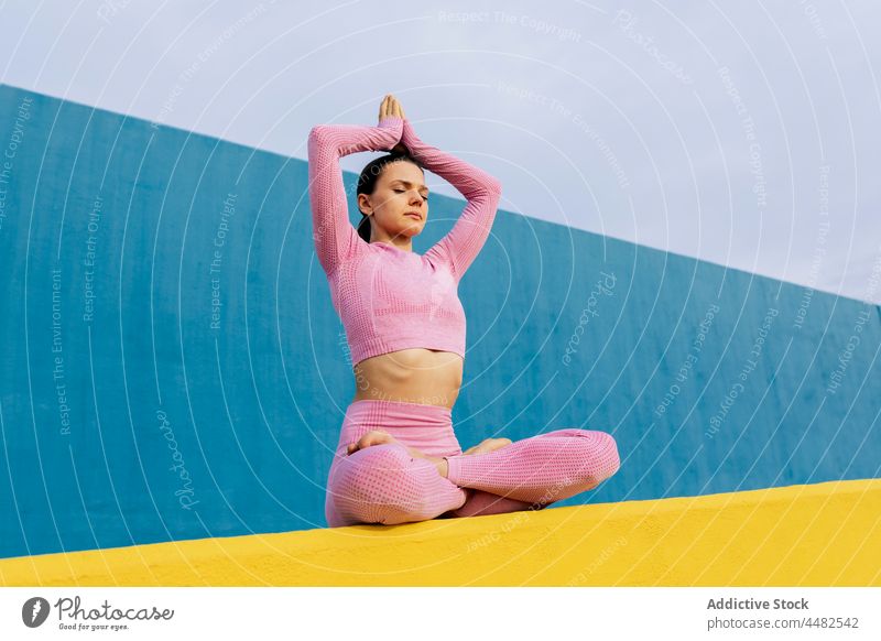 Woman with closed eyes doing yoga woman lotus pose activewear practice calm harmony asana healthy peaceful female barefoot fit wellbeing padmasansa young energy