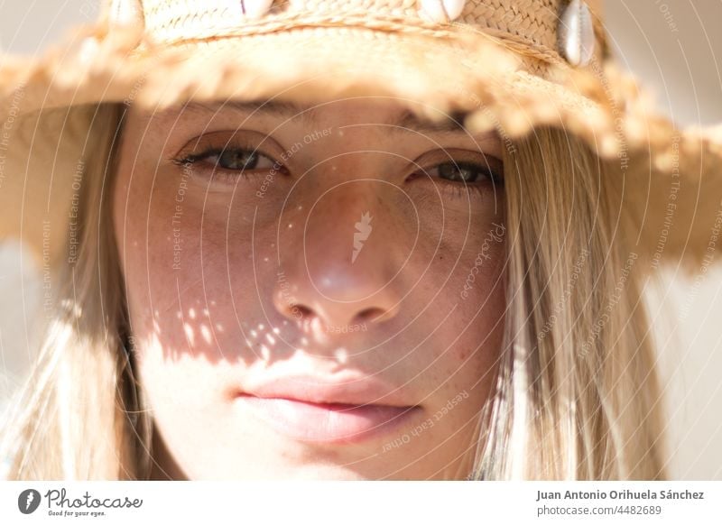Portrait of a young blonde haired woman wearing hat portrait close-up pretty straw hat lifestyle people attractive young woman girl adult person white