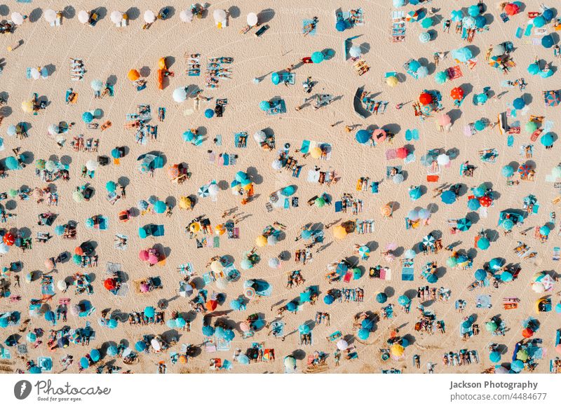 Drone shot of many people enjoying the beach and the ocean in high season- vacation pattern. crowded overcrowded texture umbrella tourists destination turquoise