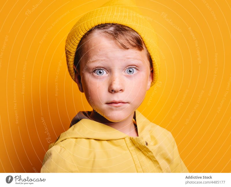 Surprised boy looking at camera against yellow wall in studio amazed surprise astonish colorful shock style autumn portrait childhood omg wow individuality