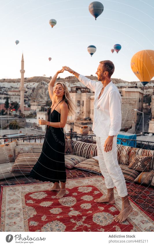 Couple dancing against flying hot air balloons couple dance soulmate rooftop date romantic together love relationship bonding weekend pleasure affection