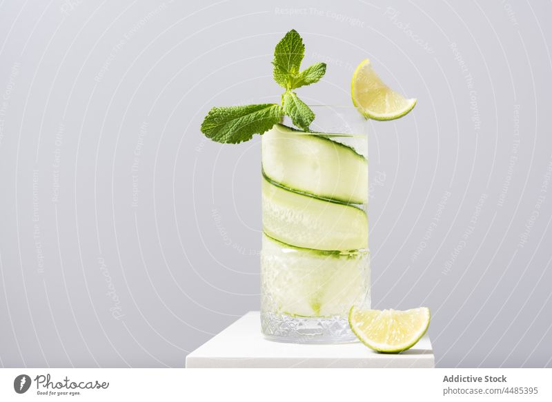 Refreshing cocktail with lime and cucumber served on white table gin tonic citrus alcohol mint beverage fruit cool ingredient delicious sour sunlight aperitif