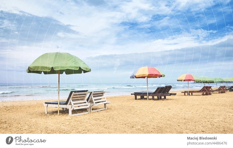 Sunbeds with sun umbrellas on an empty tropical beach, Sri Lanka. vacation sea sunbed getaway relax sand peaceful chair lounger sky water no people nature