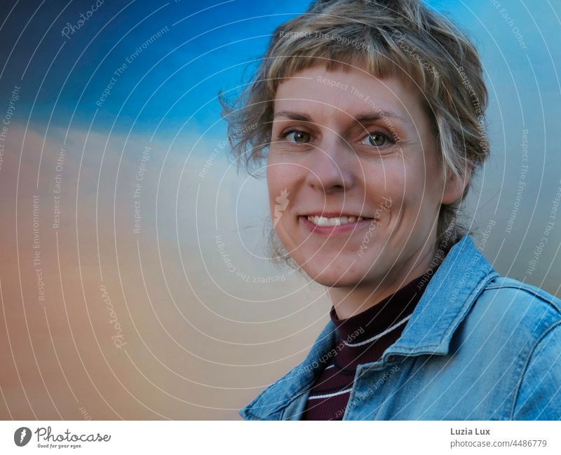 Blue hour, happy laughter: Woman with short hair looks into the camera with amusement cheerful Smiling smilingly amused Short-haired pretty Charming Happy