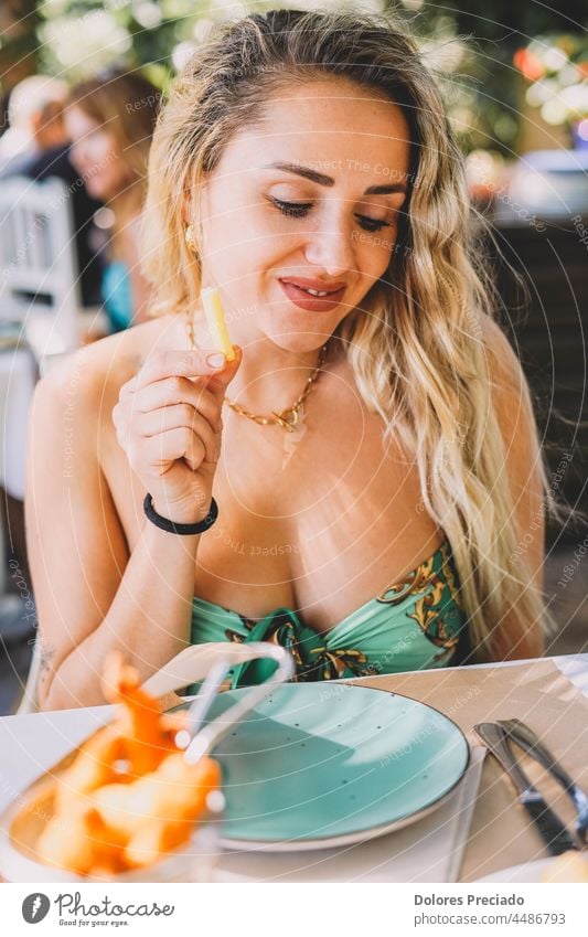 Attractive woman eating in a restaurant adult attractive beautiful beauty blond brunette carefree casual caucasian charming cheerful confident delight face