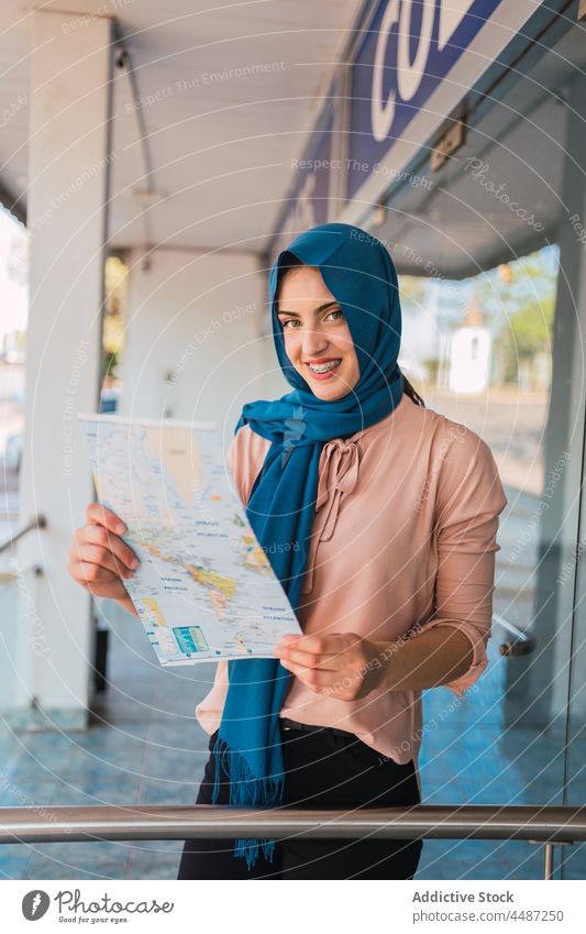 Arab woman reading paper map in city navigate orientate tourist hijab headscarf street female muslim arab ethnic culture tradition travel tourism lost guide