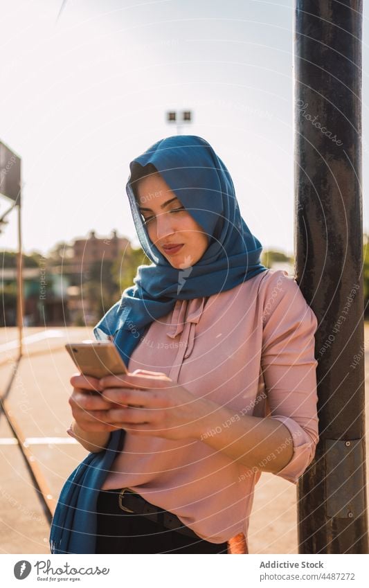 Happy Muslim woman using smartphone in street message hijab headscarf smile cheerful surfing city female ethnic arab muslim browsing online positive mobile