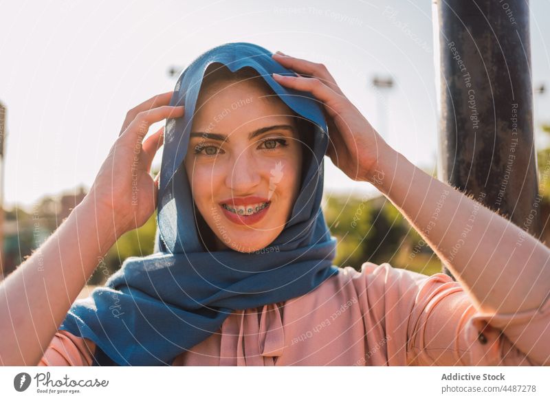 Charming Arab woman in hijab looking at camera headscarf tradition headdress smile braces charming cheerful positive female ethnic arab muslim appearance street