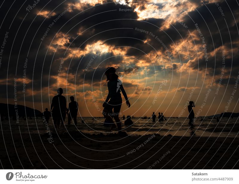 Silhouettes of people playing in the sea at a public beach silhouette landscape sky sand evening vacation sun sunset summer young ocean water nature sunlight