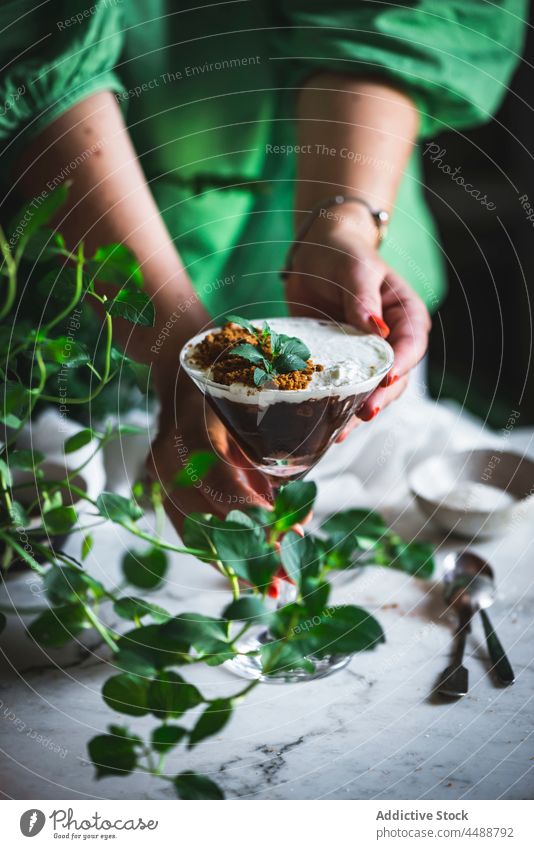 Crop woman serving mousse in glass on table chocolate coconut serve marble dessert sweet female fresh tasty delicious yummy natural mint leaf green food plant