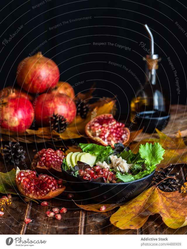 Bowl with pomegranate salad on table bowl dish autumn leaf serve food dark delicious organic olive oil meal nutrition tasty cuisine appetizing natural