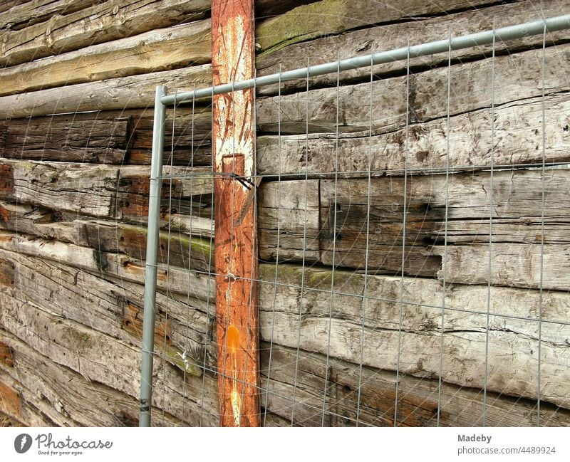 Wire mesh in front of an old high wooden fence with rusty pillar at the former inland harbour of Offenbach am Main in Hesse, Germany Wall (building) Wooden wall