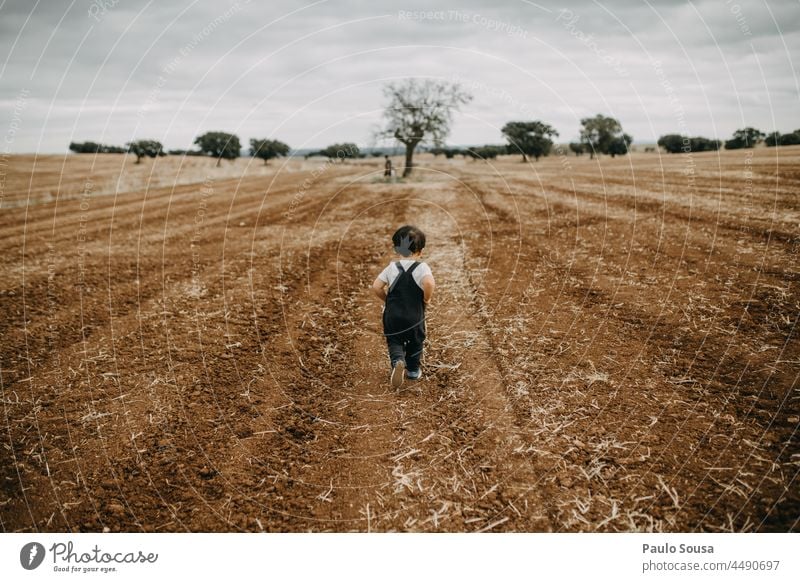 Rear view child running on plowed field Child 1 - 3 years Caucasian Running Exterior shot Colour photo Human being Infancy Joy Toddler Playing Day Happiness