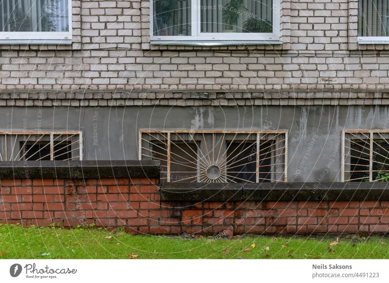 old white silicate brick wall with windows. Part of communal apartment house usual in Latvia and other eastern Europe countries. Block house for hard working people