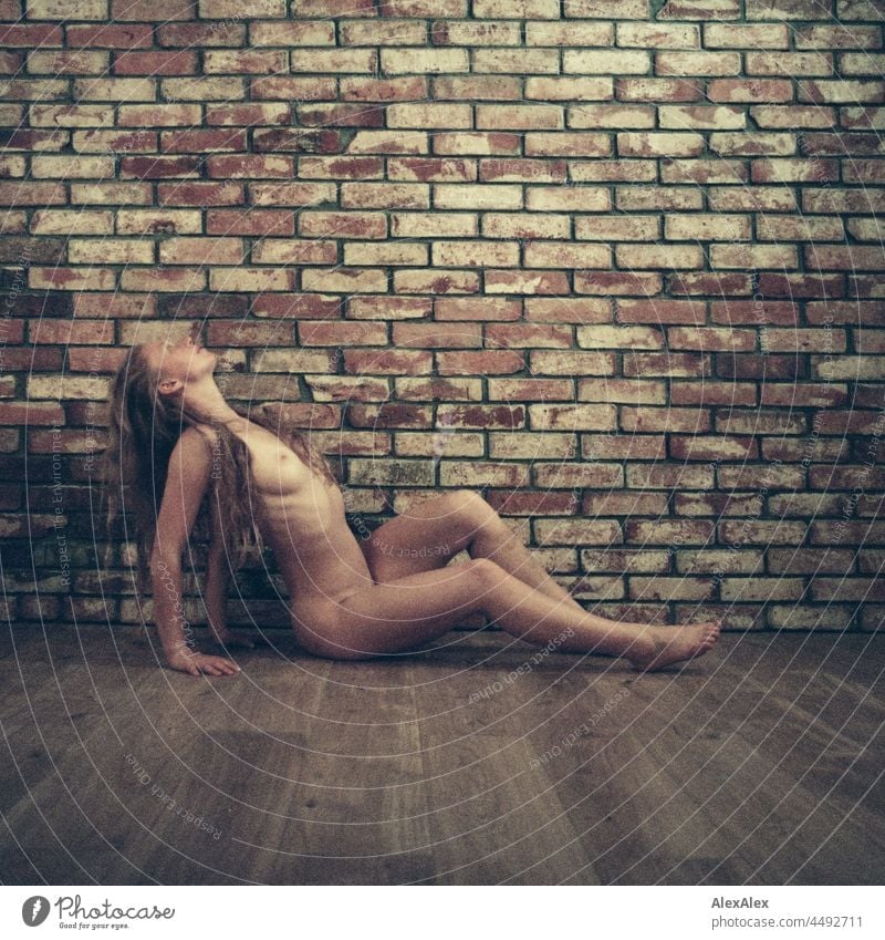 analogue nude portrait of a young woman with freckles and red hair sitting in front of a brick wall Emanation tranquillity vigorous pretty Youth (Young adults)