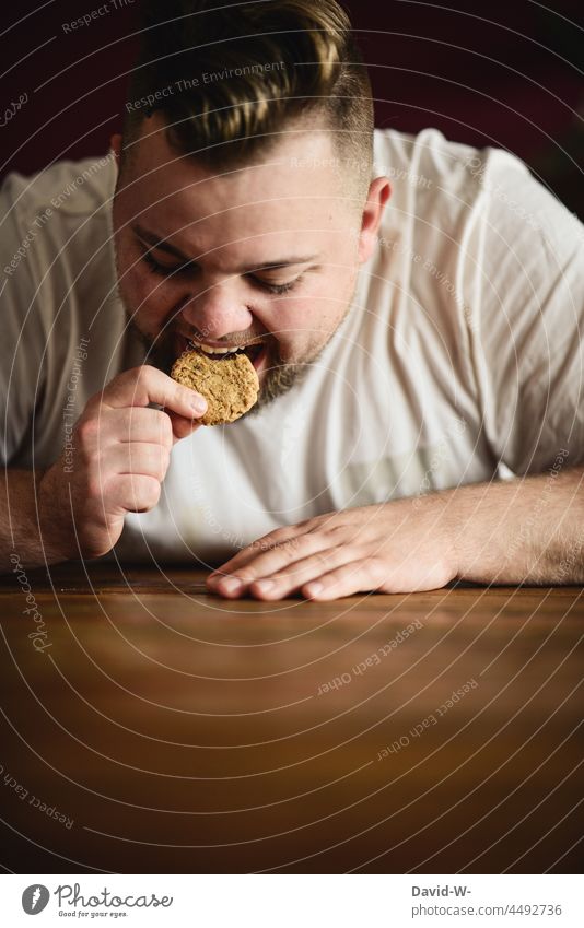 Man bites into a cookie with pleasure Eating Cookie greedy Bite Fat pleasurably hungry Overweight Appetite Weight problems gain Calorie Rich in calories Sugar