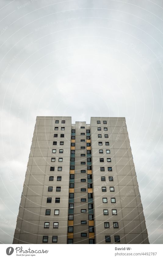 High-rise building with many windows rises into the sky Comfortless Window Sky Tall Hideous Concrete block somber dwell Hotel Building ugly Large Gray Gloomy