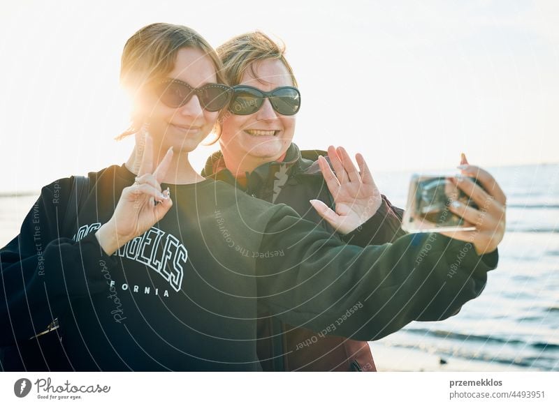 Women waving during video call on smartphone during trip on summer vacation chat gesture greeting taking photo selfie family person woman mobile phone holding