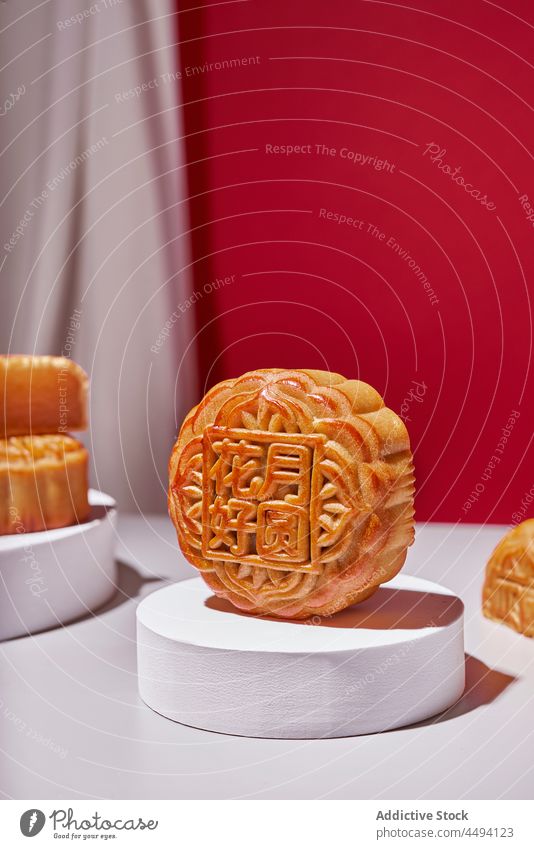 Tasty mooncake on white stand bakery pastry dessert chinese traditional sweet food treat cuisine culture studio tasty table flower delicious style baked round