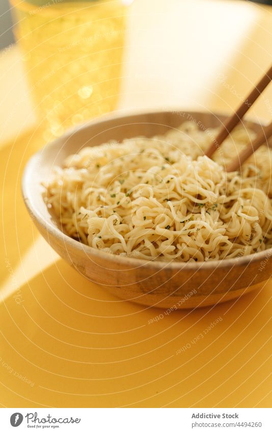 Bowl of noodles and chopsticks bowl asian food dish meal serve cuisine seasoning condiment tasty delicious table yummy palatable portion glass delectable