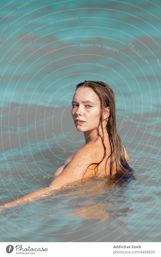 Attractive woman in sea water naked wet hair daylight summer nature nude calm female sensual stand alone seascape charming ripple daytime aqua attractive gaze