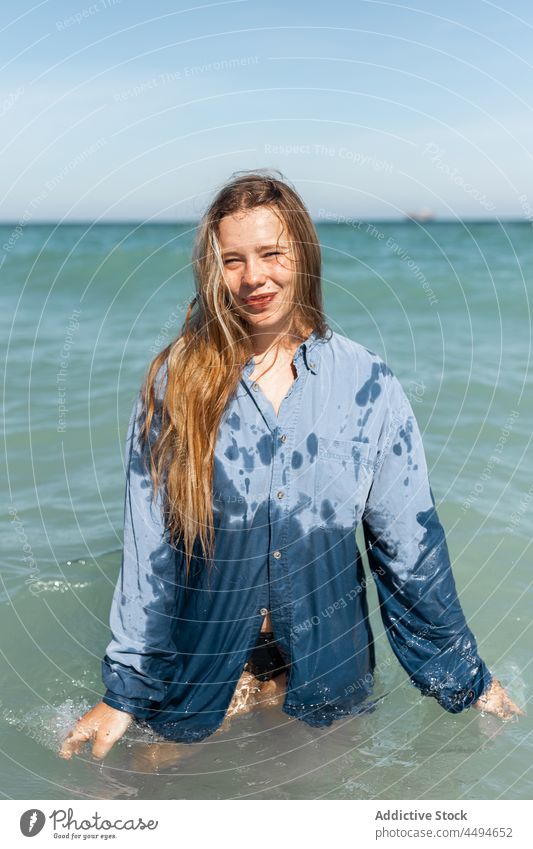 Woman in wet shirt standing in sea woman water nature observe explore wait summer happy delight peaceful sunlight female smile enjoy charming young calm glad