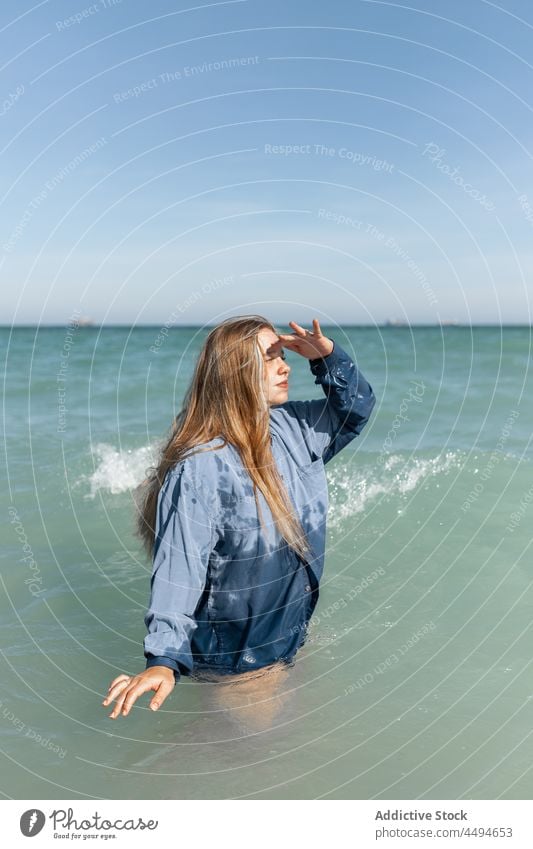 Woman in wet shirt standing in sea woman water nature distance observe explore wait summer happy peaceful sunlight female enjoy charming young calm aqua