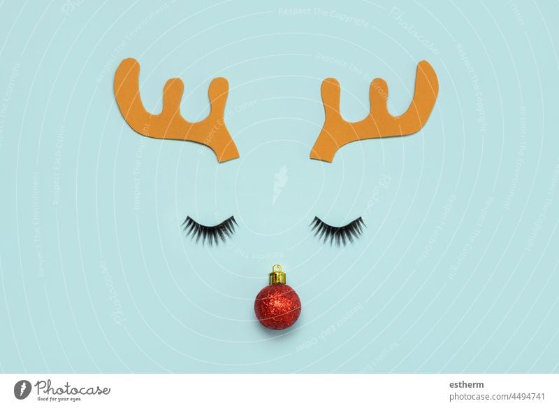 Merry Christmas.Christmas Rudolph reindeer horns with false eyelashes and red christmas ball.Christmas concept background santa claus fun celebration