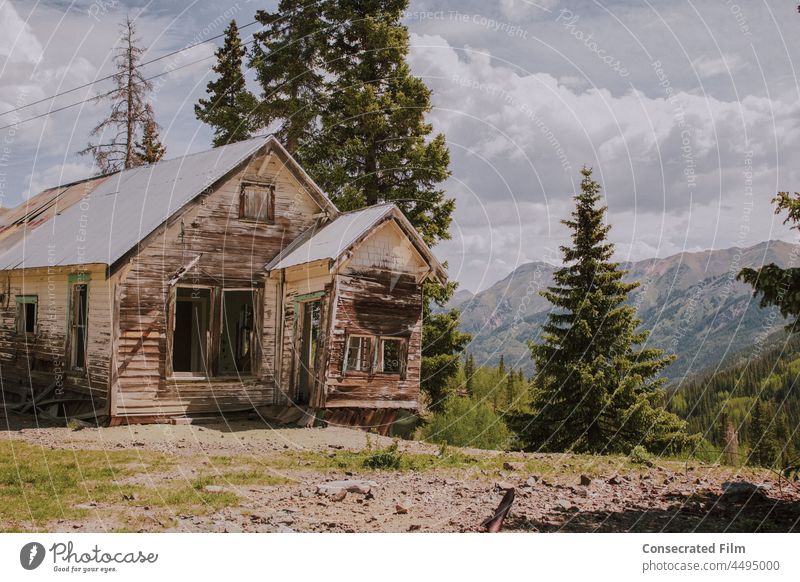 Old abandoned house in the middle of the mountains, at a ghost town Ghost town travel adventure Wooden house Deserted Western Haunted house Wild West trees