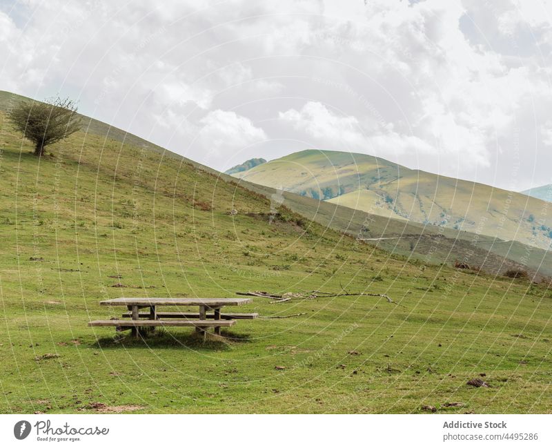 Hilly terrain with wooden table hill countryside rustic nature field environment hillside landscape bench scenery scenic green summer natural greenery verdant