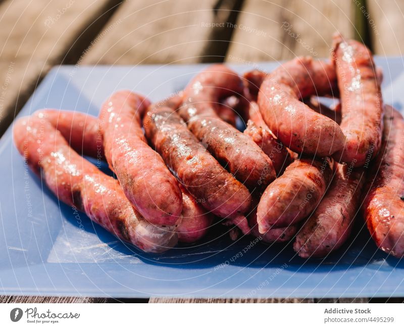 Heap of roasted sausages on table meat food grilled countryside meal bbq serve calorie pile tasty delicious summer wooden yummy cutting board fresh lunch
