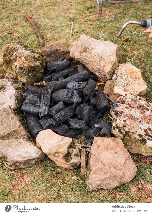 Burning firewood with orange flames in daytime bonfire charcoal campfire burner torch burn up stone spark blaze material flammable hot heat campsite rough