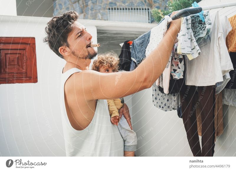 Young man doing the laundry at home clothes wash clean fresh doing laundry backyarkd family baby male modern masculinity youth parent outdoors aire warm dryed