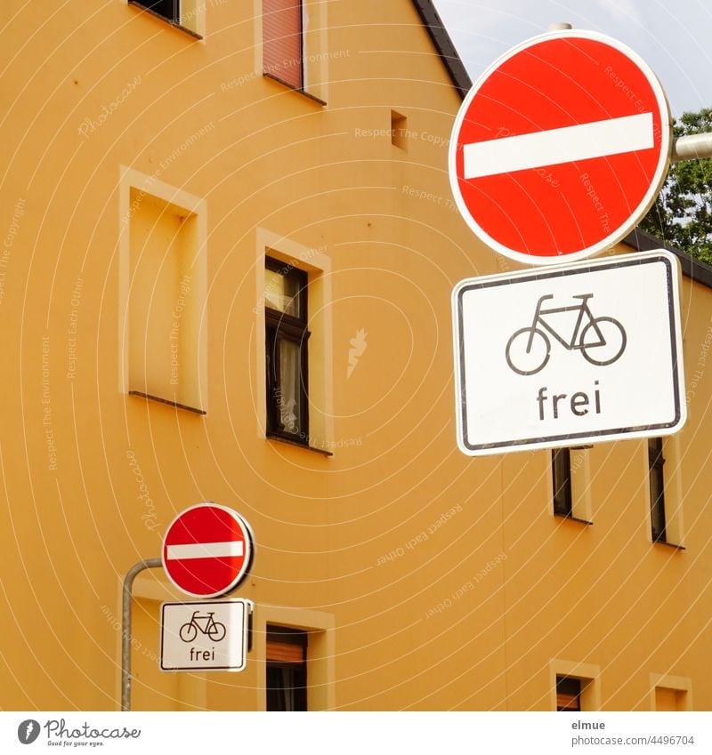 Signs I In front of a yellow house on the left and right side of the road there are traffic signs - prohibition of entry - with additional sign - cyclist free - / VZ 267 / VZ 1022-10 / one-way street