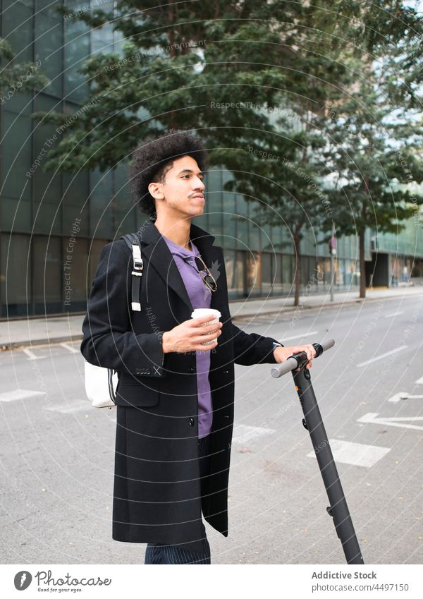 Trendy ethnic guy with scooter drinking takeaway coffee on street man style self assured walk elegant african american man fashion appearance city trendy male